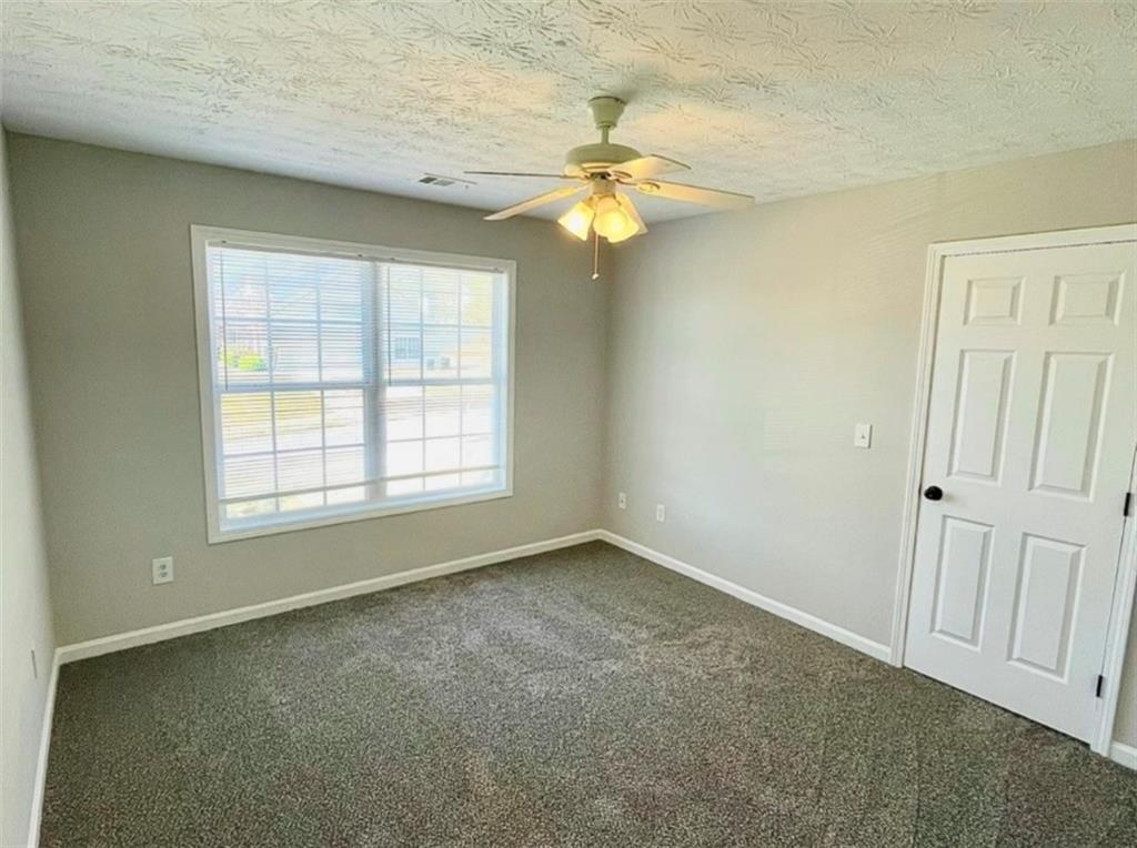 2225 Blue Ridge Lane Conyers, GA 30012 - Photo 23 of 40 an empty room with a window and a chandelier fan