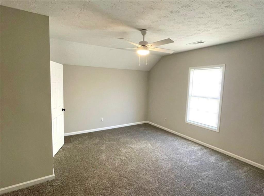 2225 Blue Ridge Lane Conyers, GA 30012 - Photo 24 of 40 an empty room with a ceiling fan and a window