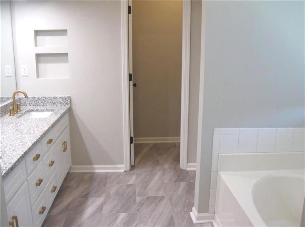 2225 Blue Ridge Lane Conyers, GA 30012 - Photo 27 of 40 a bathroom with a granite countertop sink a mirror and a bathtub