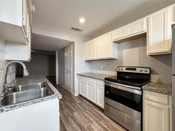 a kitchen with a refrigerator and a stove top oven