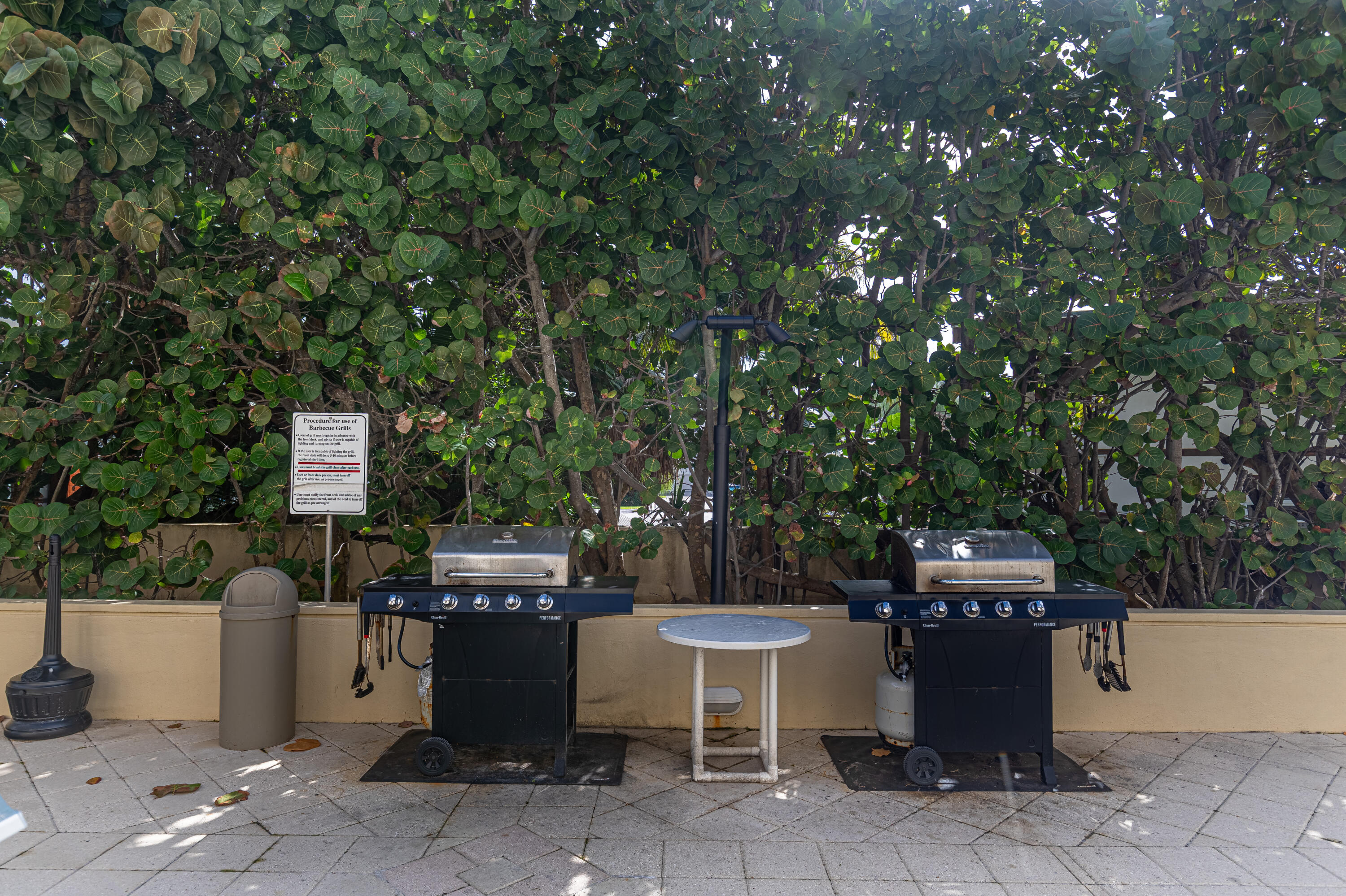 3475 South Ocean Boulevard, Unit 201 Palm Beach, FL 33480 - Photo 28 of 28 a view of a patio with table and chairs potted plants with wooden fence
