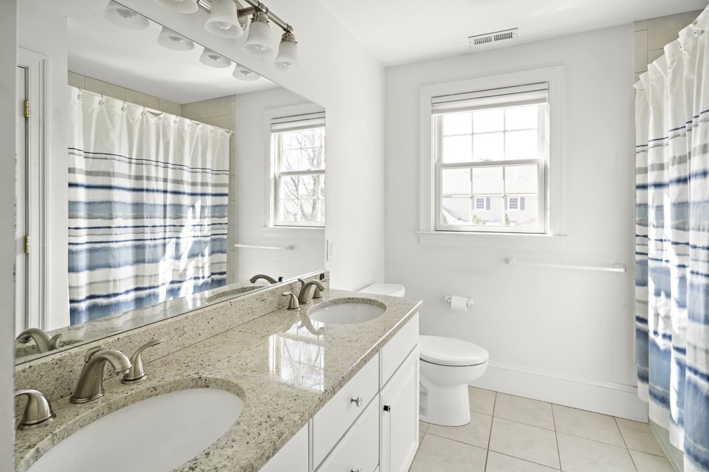 4 Colonial Drive Arlington, MA 02474 - Photo 15 of 19 a bathroom with a granite countertop double vanity sink a mirror and a toilet
