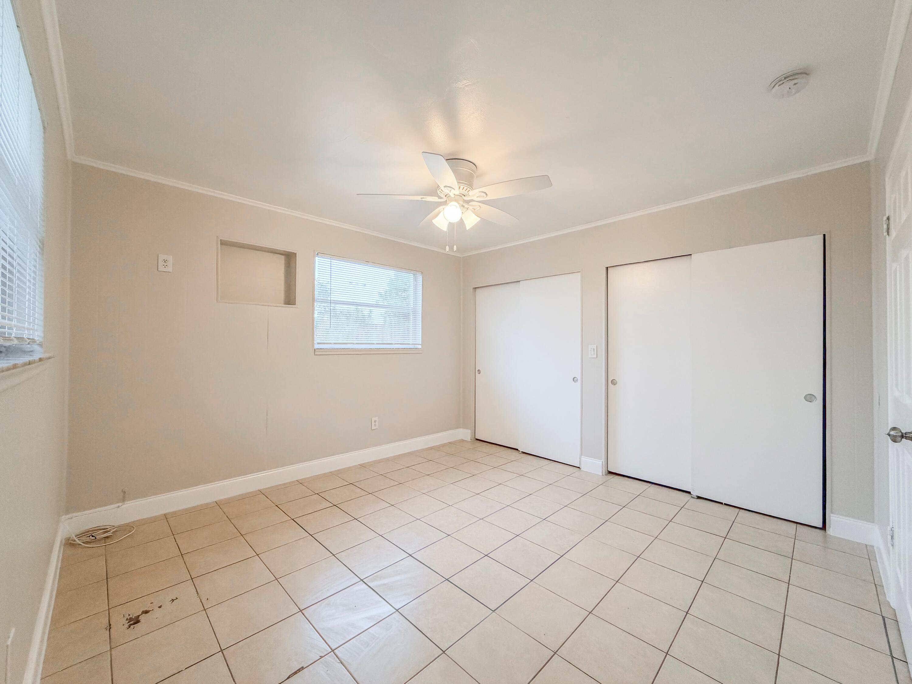 3077 Floweva Street Palm Springs, FL 33406 - Photo 5 of 12 wooden floor in an empty room with a window