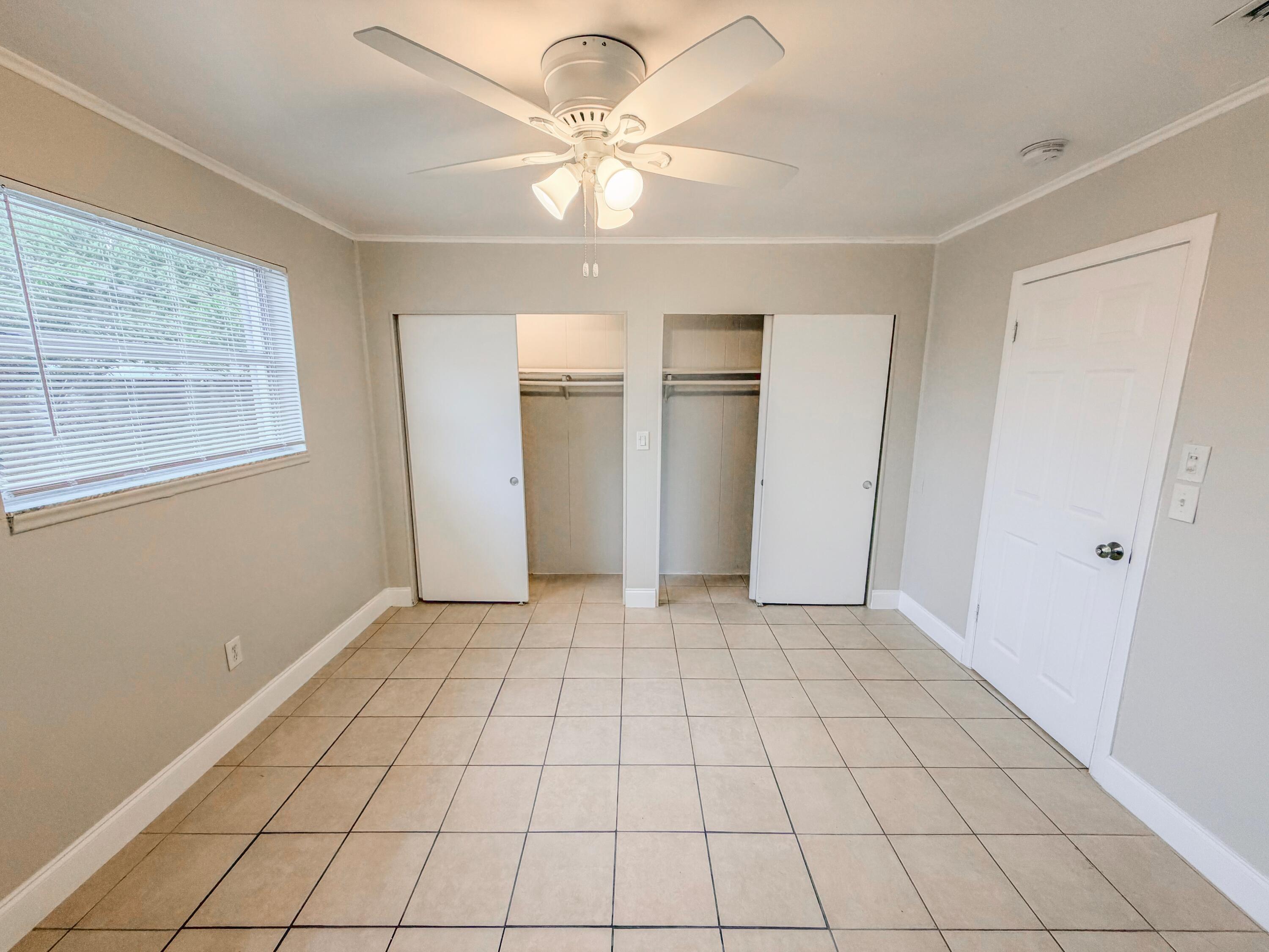 3077 Floweva Street Palm Springs, FL 33406 - Photo 6 of 12 a view of an empty room with window and chandelier fan