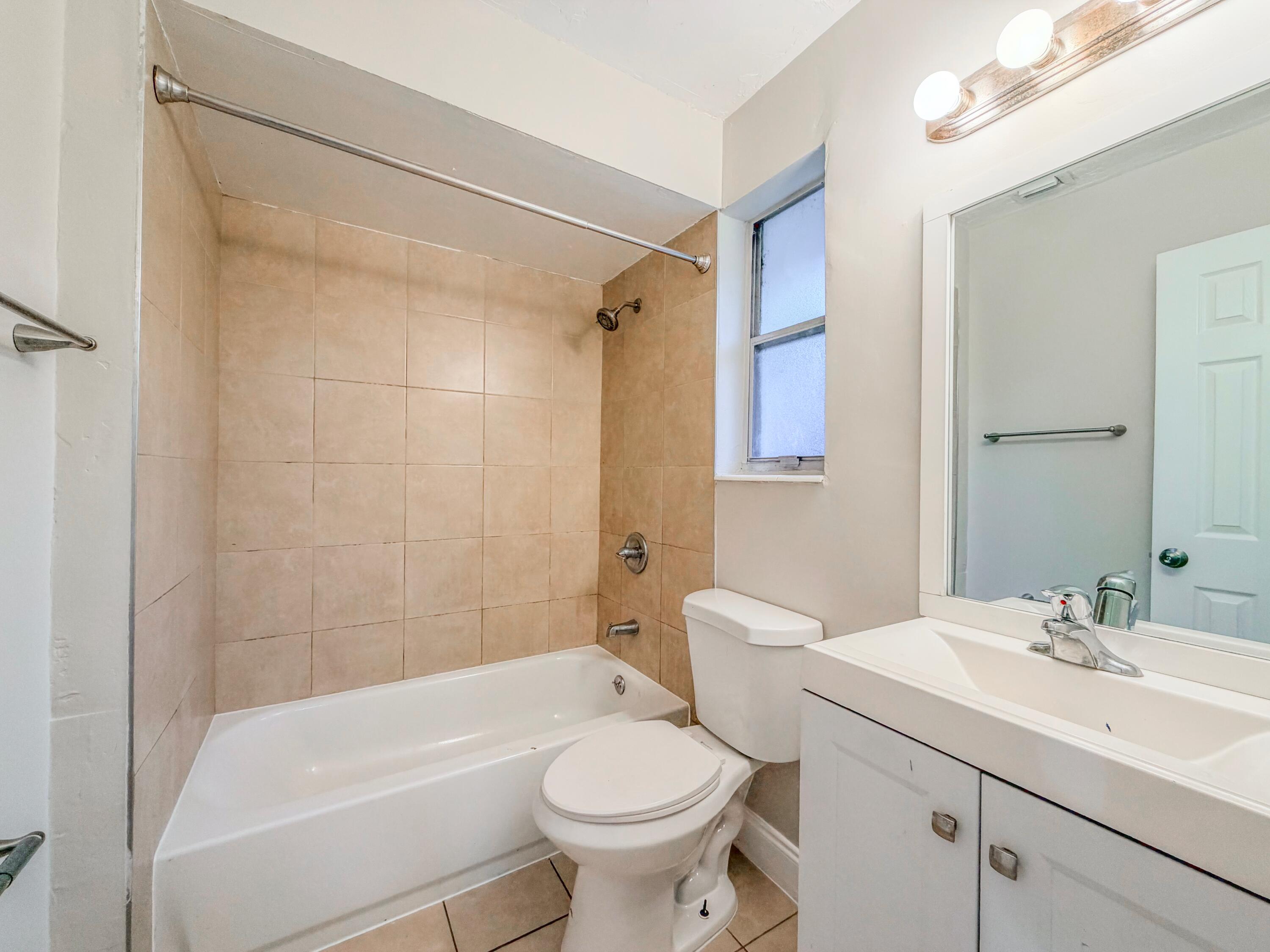 3077 Floweva Street Palm Springs, FL 33406 - Photo 7 of 12 a bathroom with a sink toilet and shower