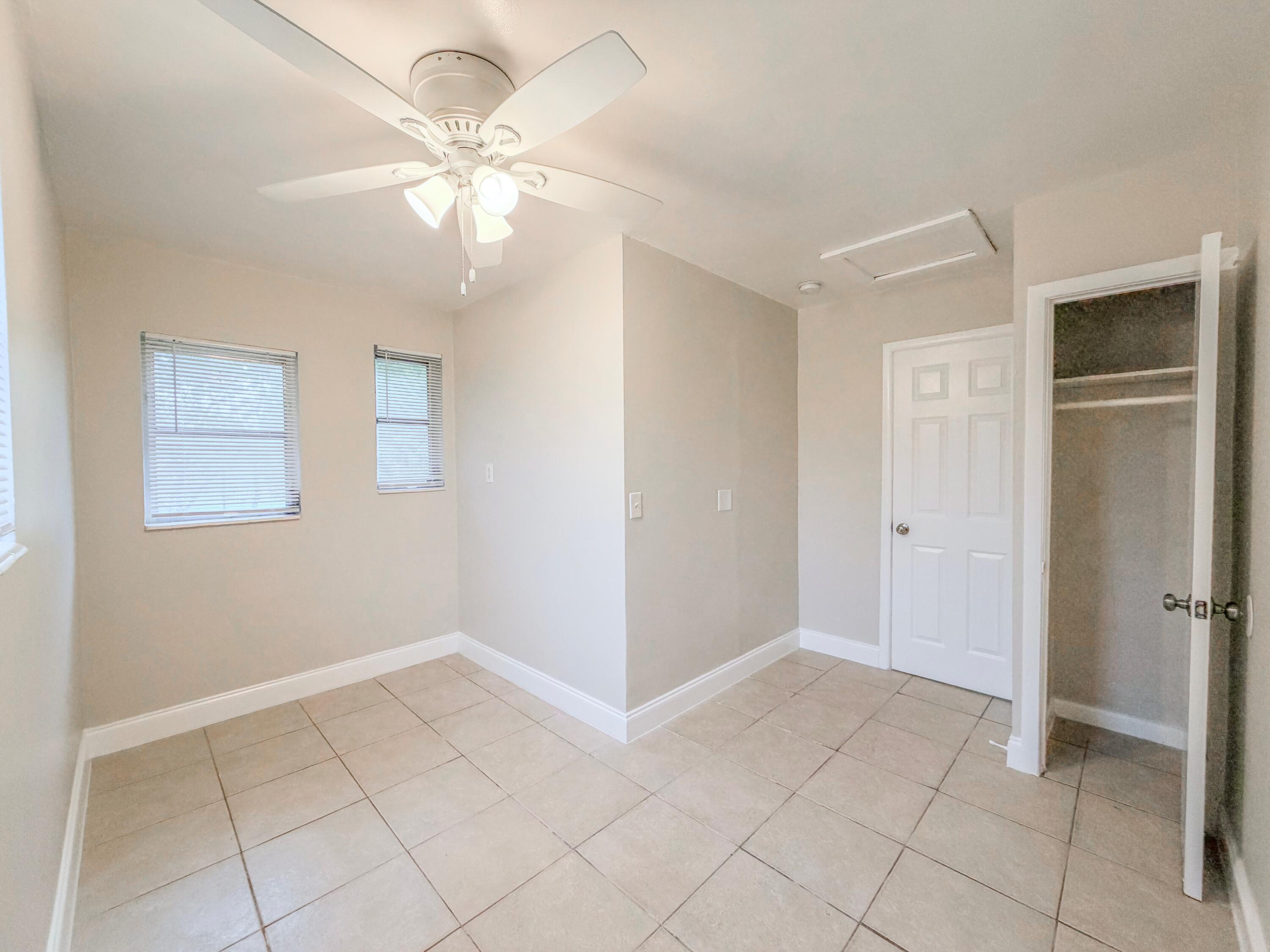 3077 Floweva Street Palm Springs, FL 33406 - Photo 9 of 12 a view of an empty room with cabinet and a chandelier fan