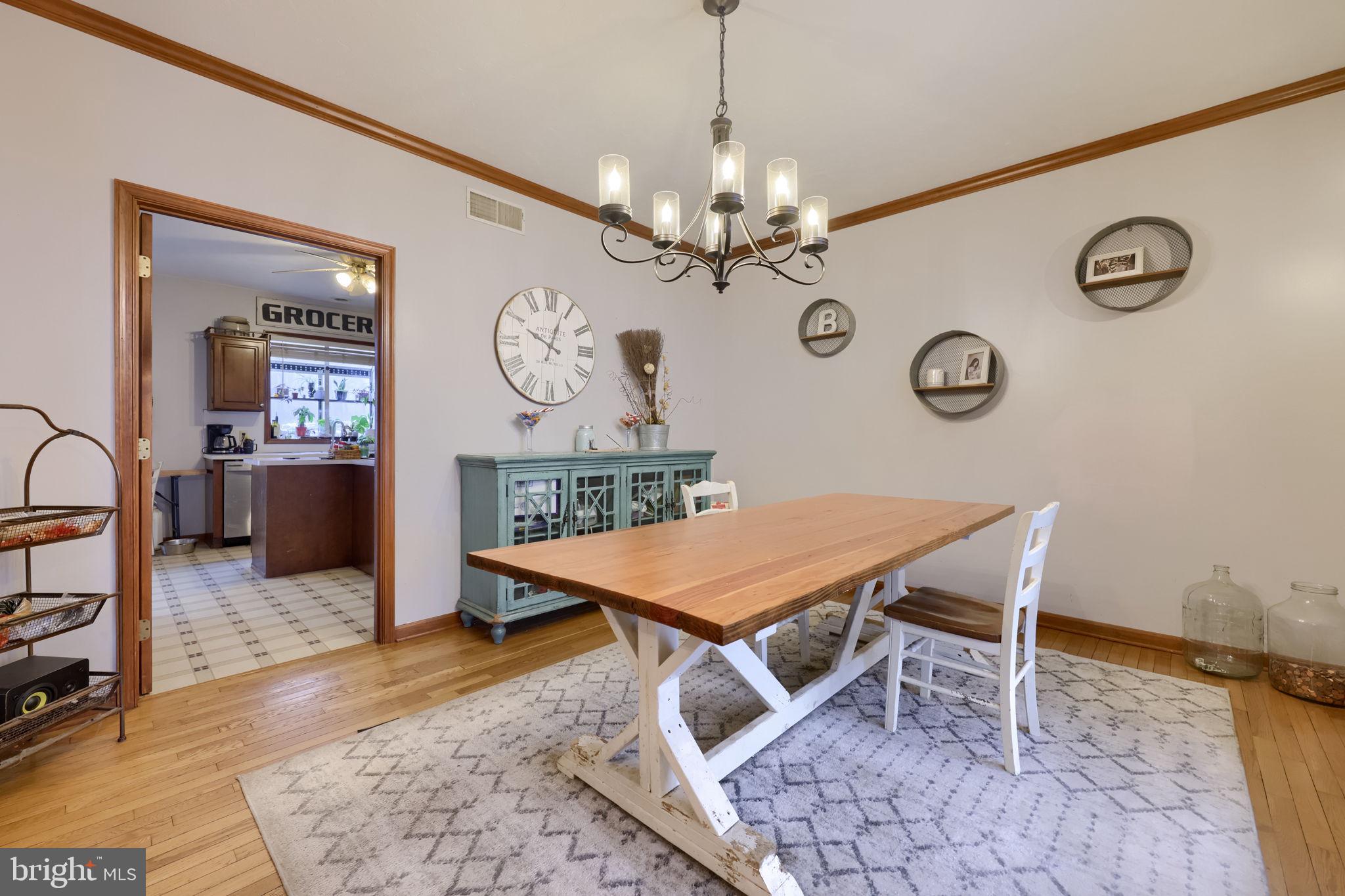 180 Springvale Road Red Lion, PA 17356 - Photo 11 of 70 a dining room with wooden floor a chandelier a wooden table and chairs