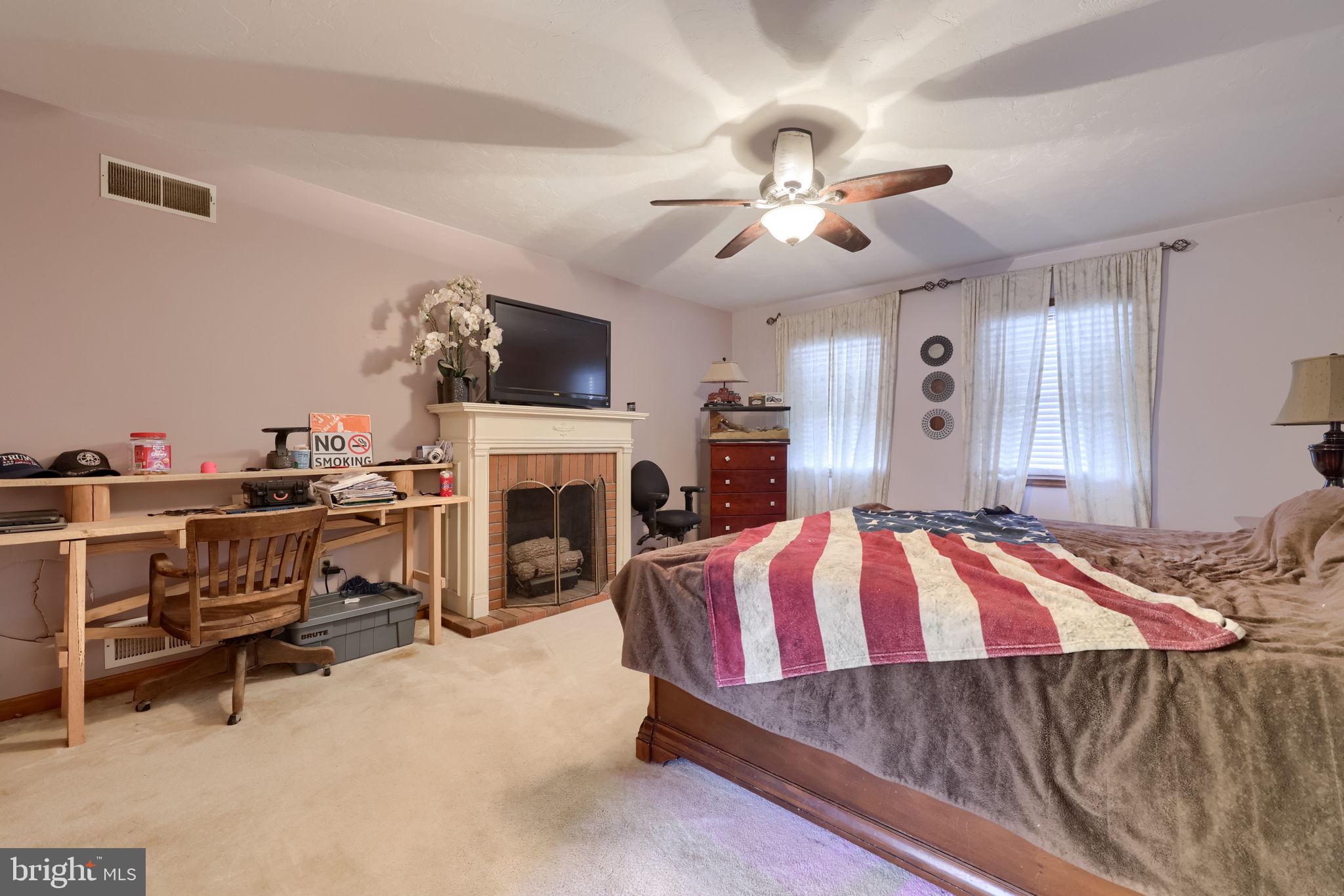 180 Springvale Road Red Lion, PA 17356 - Photo 25 of 70 a spacious bedroom with a bed a fireplace and a chandelier