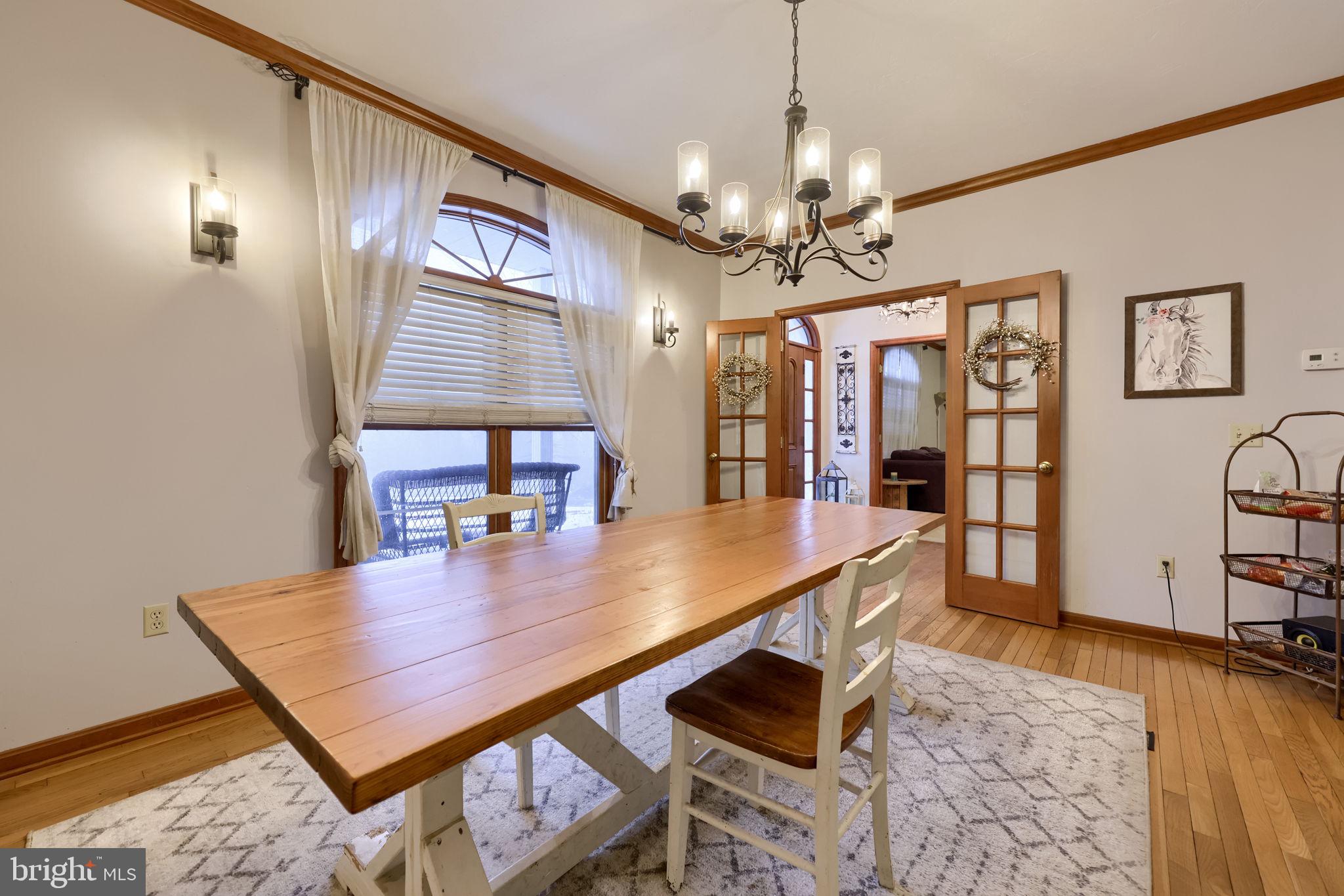 180 Springvale Road Red Lion, PA 17356 - Photo 9 of 70 a dining room with wooden floor a chandelier a wooden table and chairs