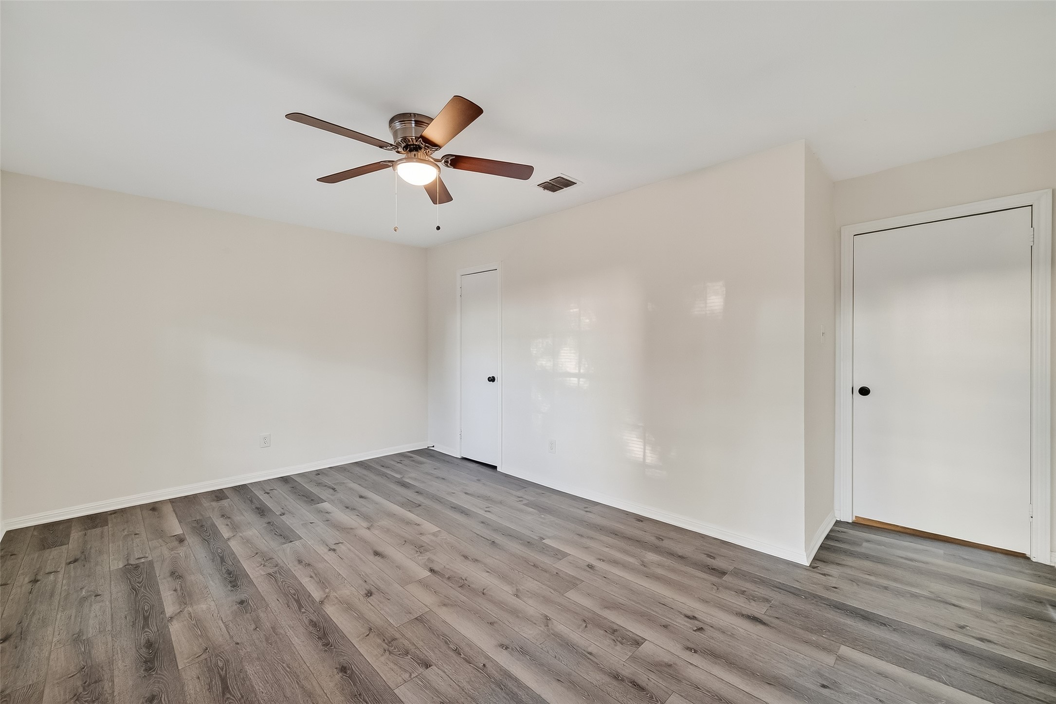 26522 Hillside Drive Spring, TX 77386 - Photo 29 of 45 an empty room with wooden floor a ceiling fan and windows