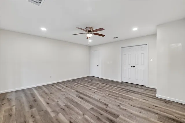 wooden floor in an empty room with a ceiling fan