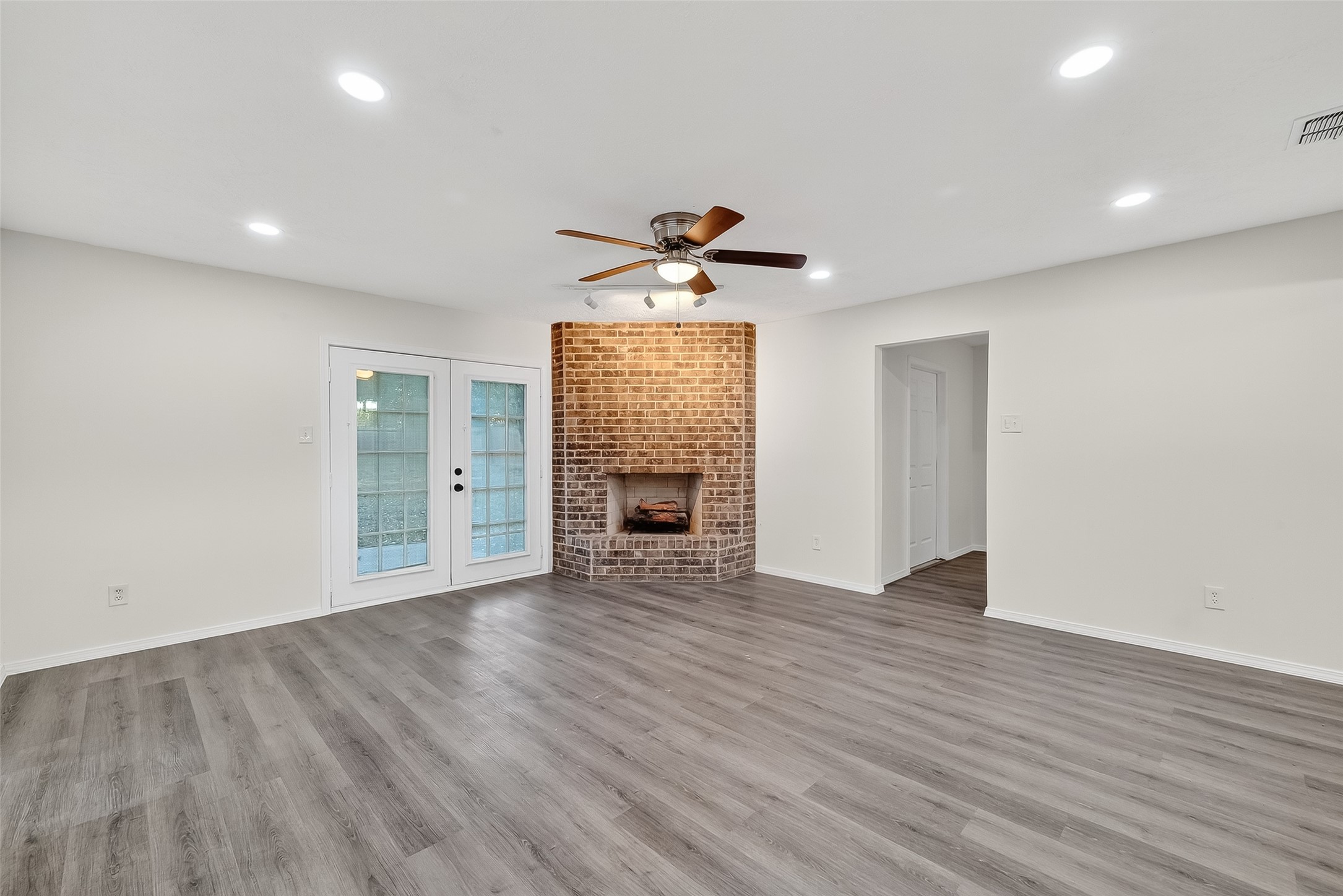 26522 Hillside Drive Spring, TX 77386 - Photo 9 of 45 an empty room with wooden floor a ceiling fan and windows