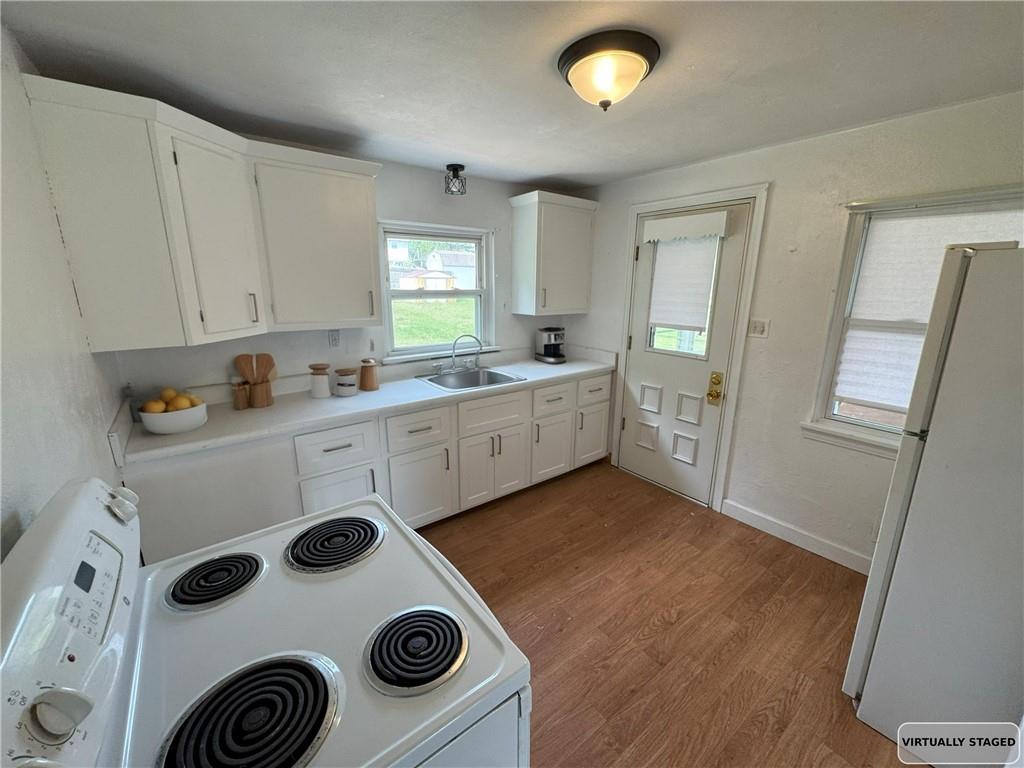 488 Meadow Road Irwin, PA 15642 - Photo 7 of 23 a kitchen with a refrigerator a stove and wooden floor