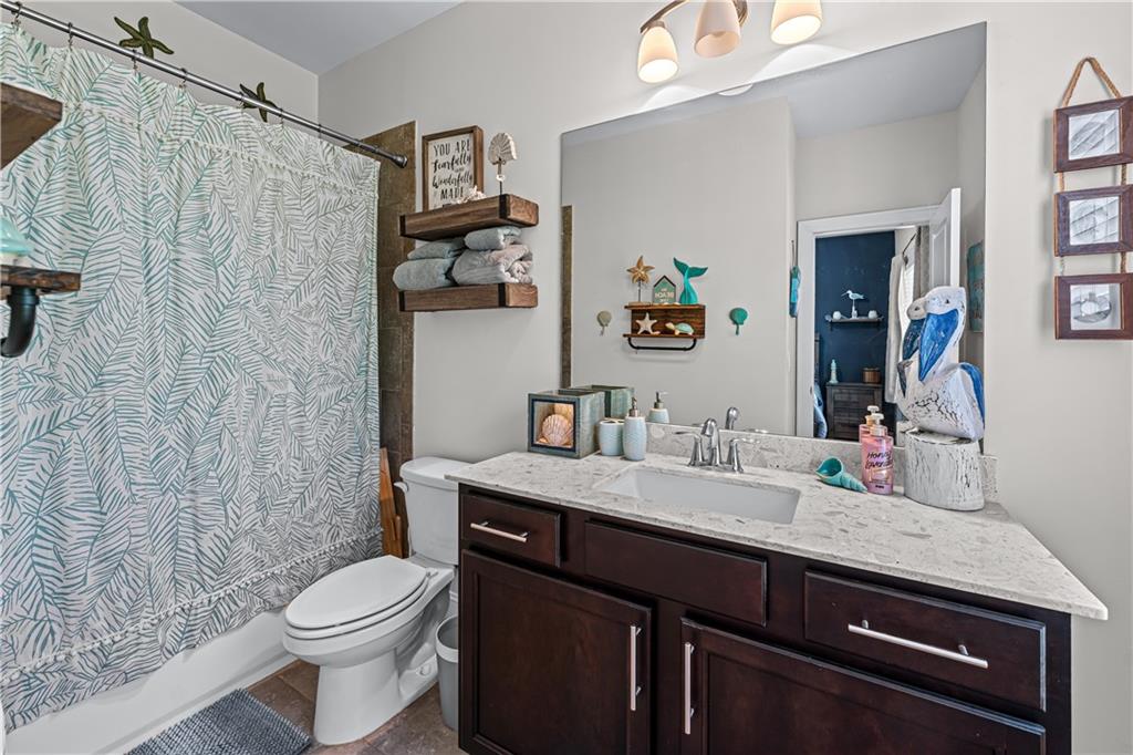 3766 Alstead Manor Way Suwanee, GA 30024 - Photo 24 of 41 a bathroom with a granite countertop sink a toilet and a shower curtain