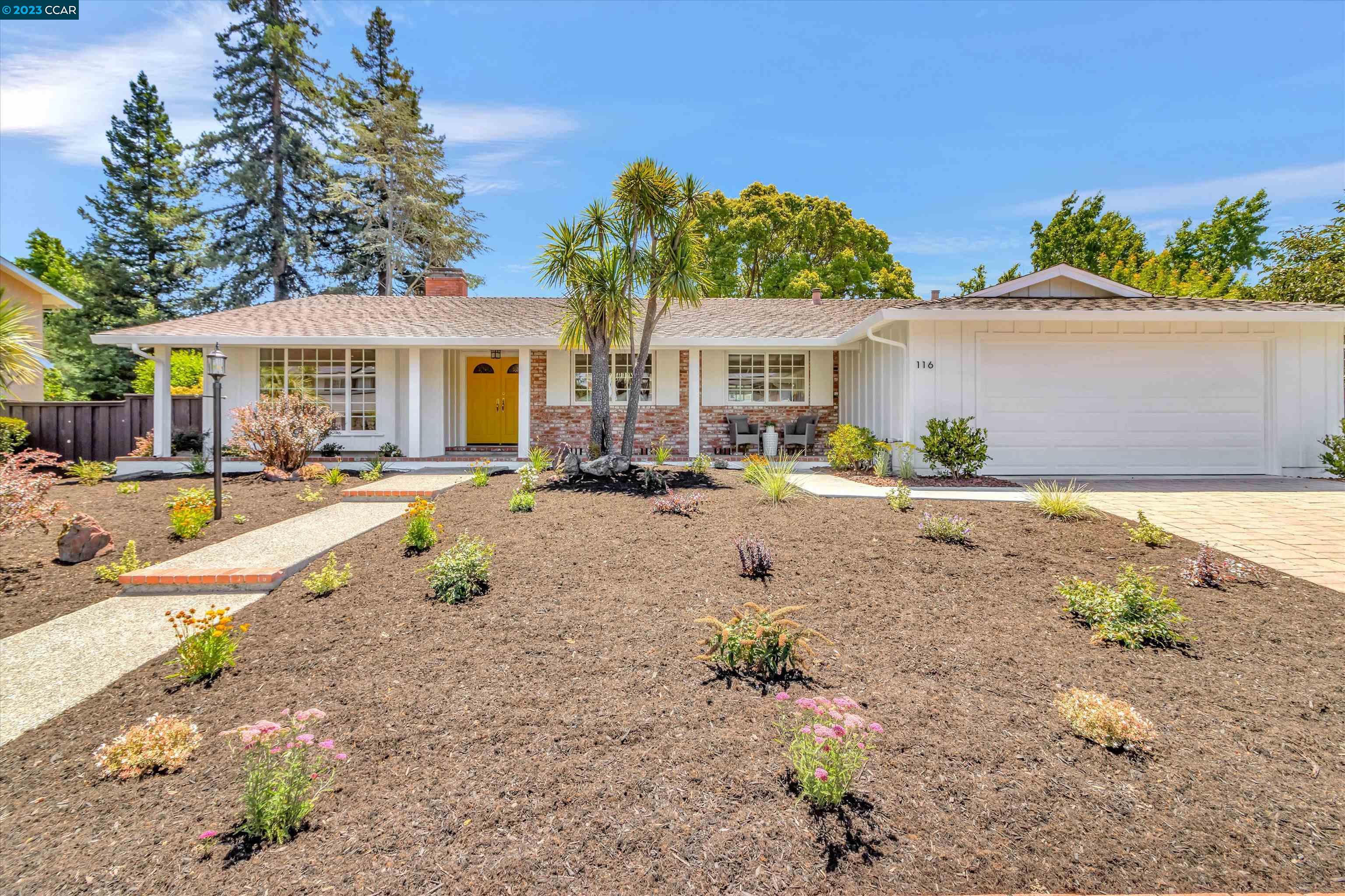a view of a house with a yard and sitting area