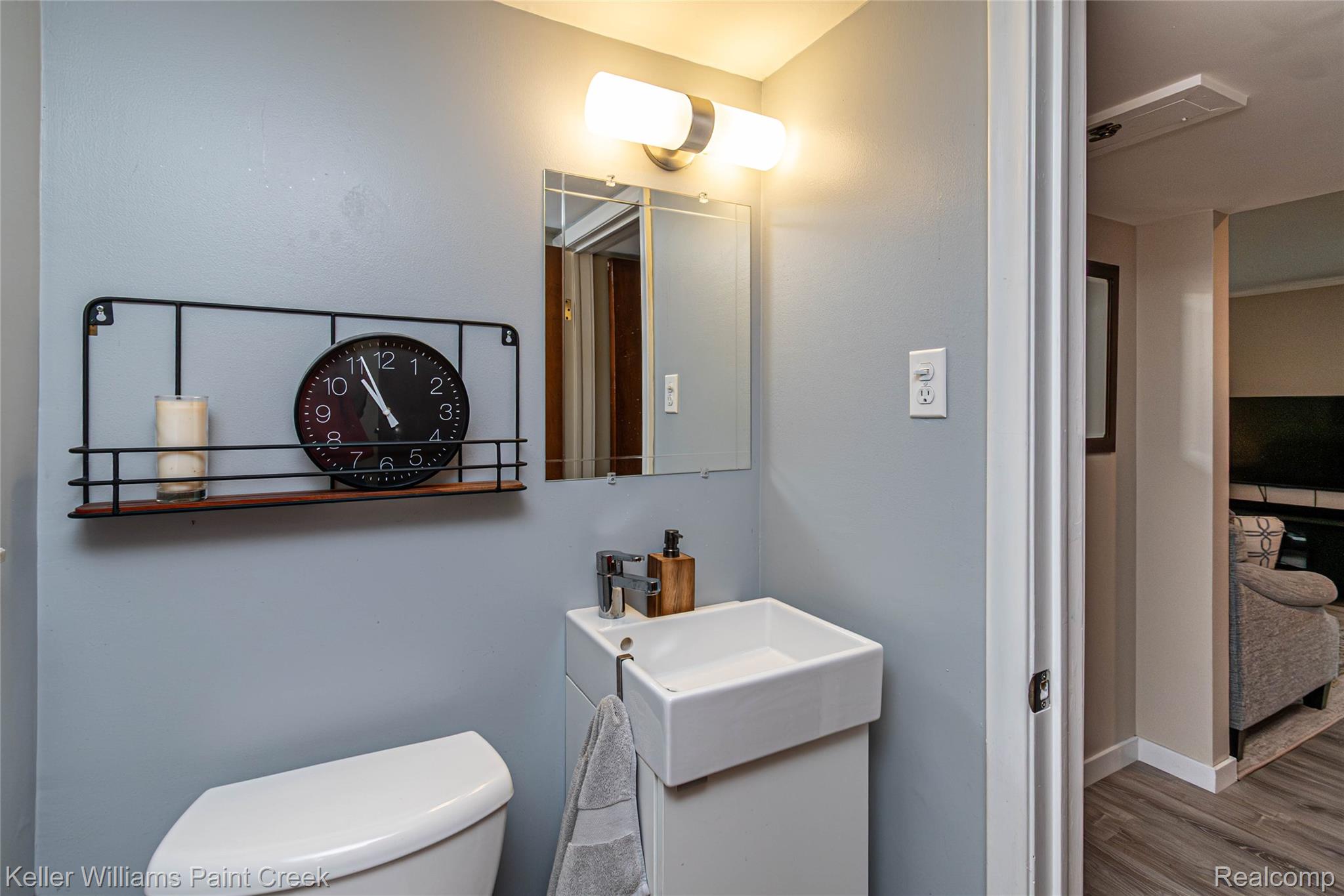 7093 Stonebrook Road West Bloomfield, MI 48322 - Photo 51 of 64 Modern bathroom featuring a rectangular vessel sink with a single-handle faucet, wall-mounted vanity lighting, and a framed mirror