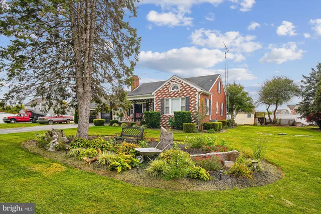 a view of a house with a big yard and large trees