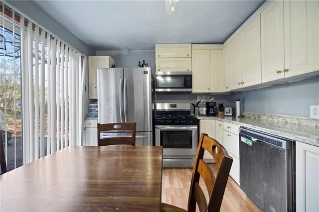 a kitchen with stainless steel appliances a stove a sink and white cabinets