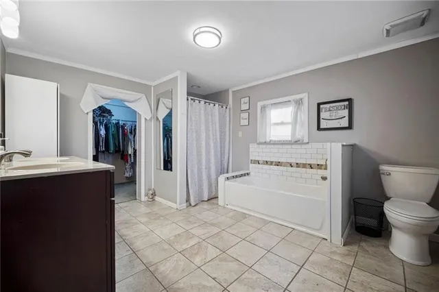 a spacious bathroom with a sink a toilet and a mirror