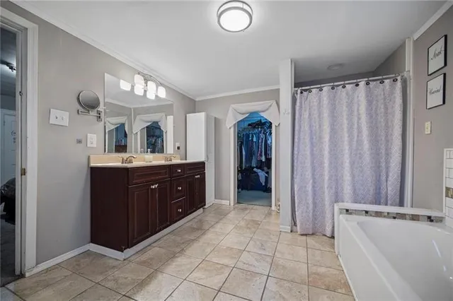 a spacious bathroom with a double vanity sink a mirror and a shower