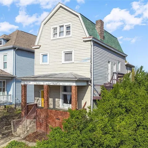a view of a white house next to a yard