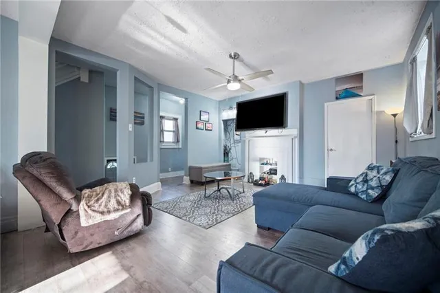 a living room with furniture a flat screen tv and a fireplace