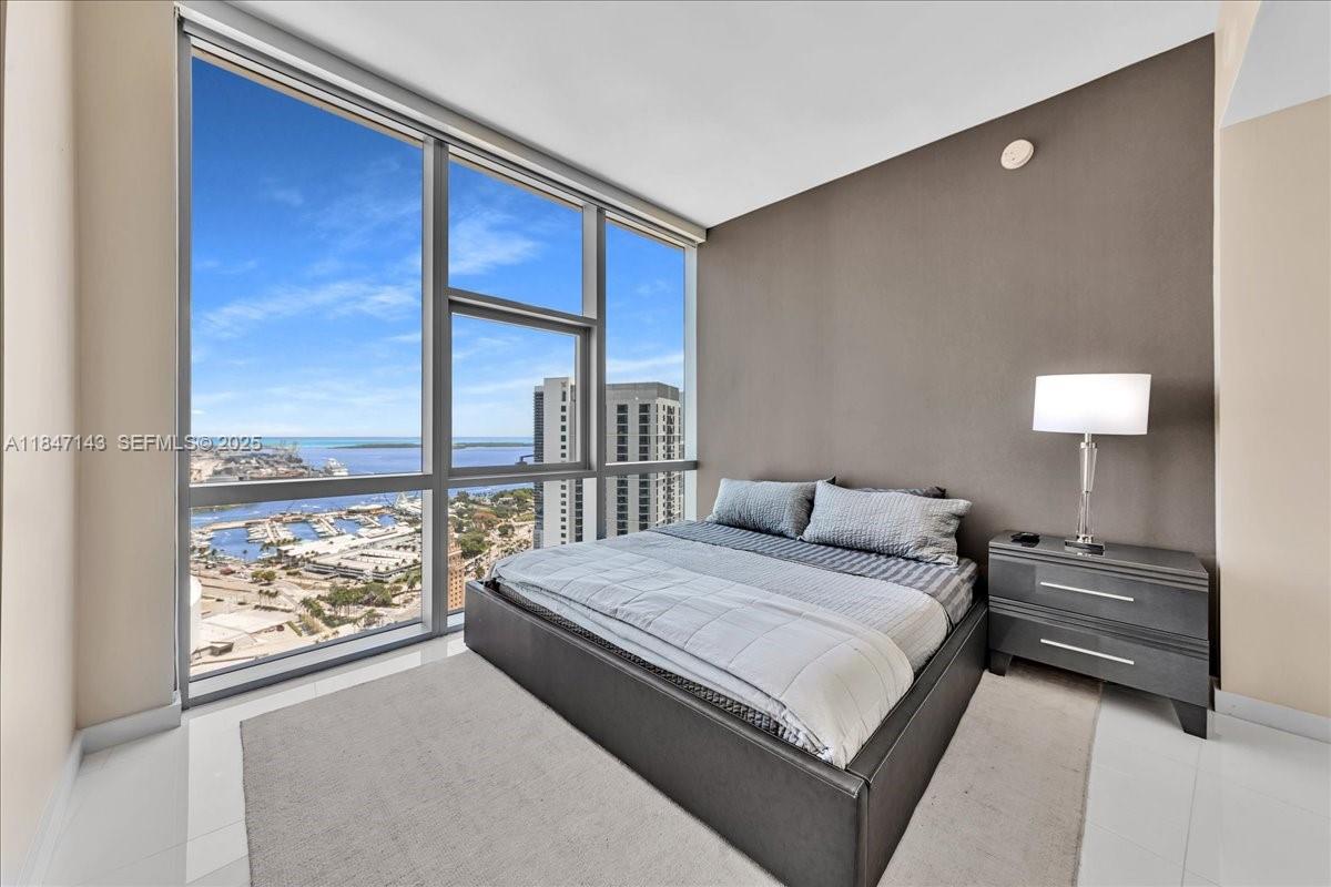 851 Northeast 1st Avenue, Unit 3711 Miami, FL 33132 - Photo 13 of 47 a bedroom with a large bed and a window