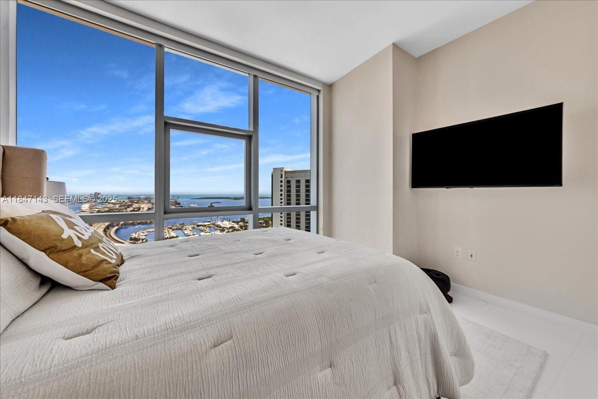 851 Northeast 1st Avenue, Unit 3711 Miami, FL 33132 - Photo 16 of 47 a bedroom with a bed and a flat screen tv