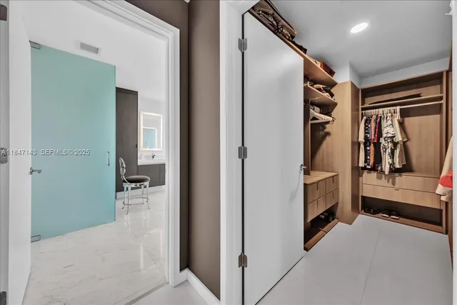 a view of walk in closet with clothes and shoes