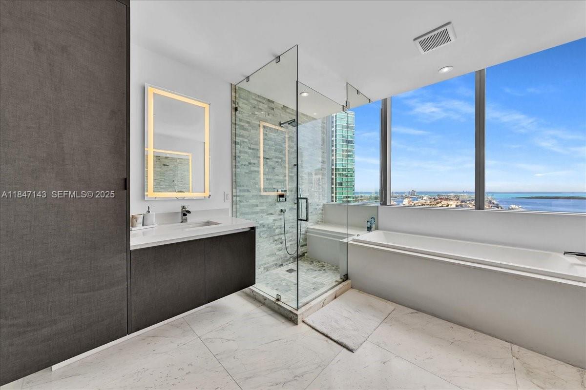 851 Northeast 1st Avenue, Unit 3711 Miami, FL 33132 - Photo 24 of 47 a bathroom with a large tub sink shower and view