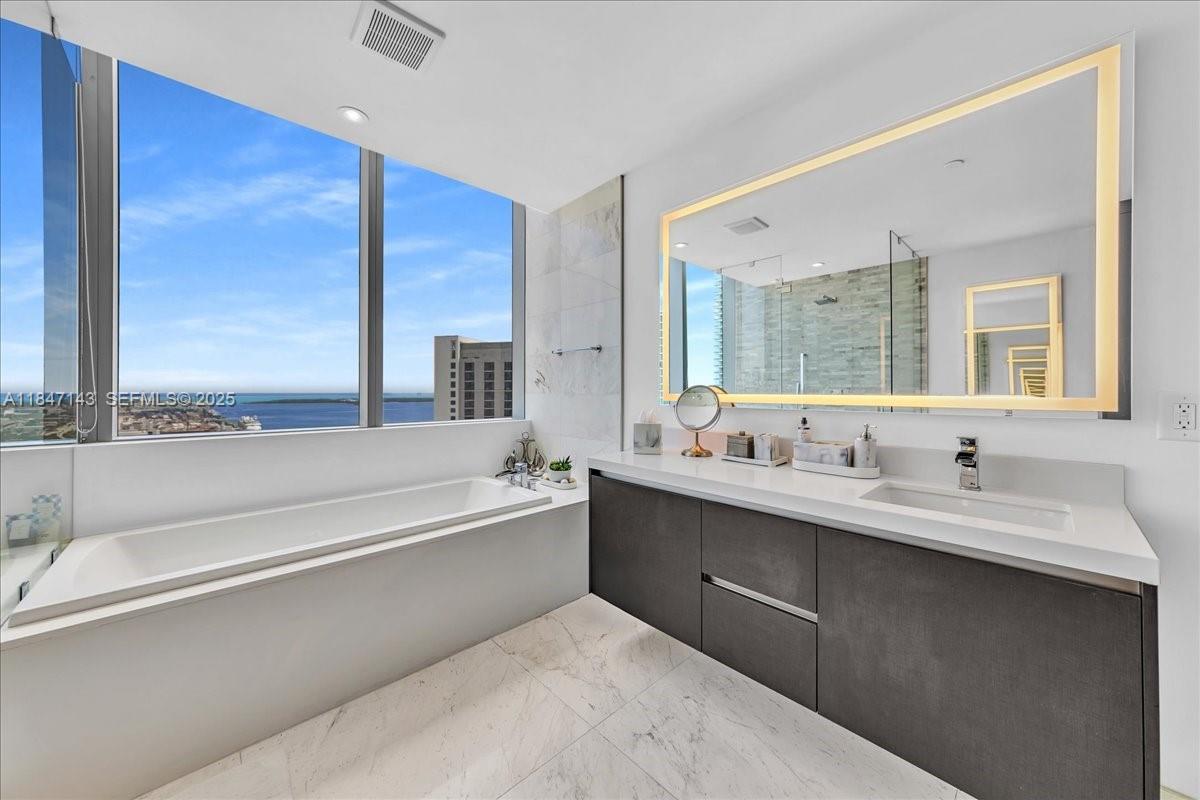 851 Northeast 1st Avenue, Unit 3711 Miami, FL 33132 - Photo 25 of 47 a bathroom with a tub sink and mirror