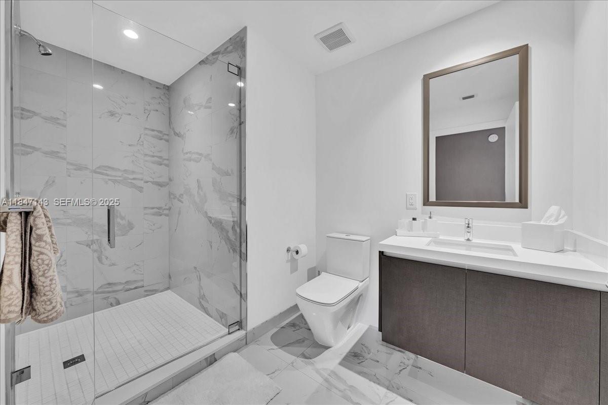 851 Northeast 1st Avenue, Unit 3711 Miami, FL 33132 - Photo 34 of 47 a bathroom with a sink a toilet and shower