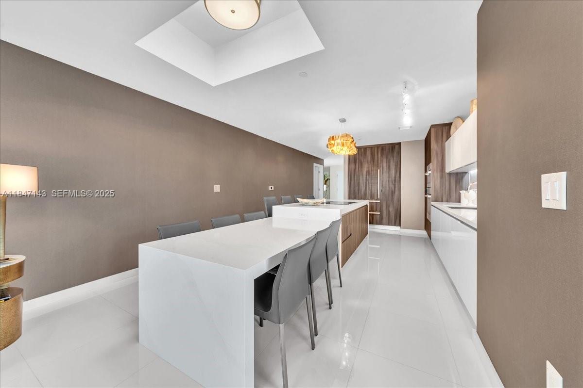 851 Northeast 1st Avenue, Unit 3711 Miami, FL 33132 - Photo 10 of 47 a kitchen with stainless steel appliances a white refrigerator a sink a dining table and chairs