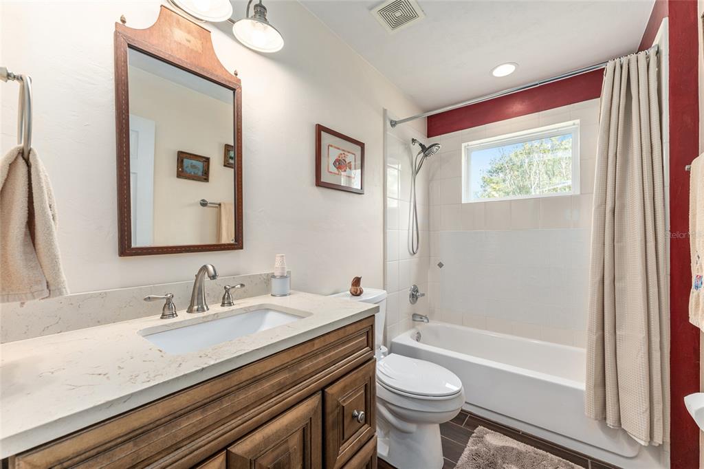 8420 Southwest 92nd Lane Gainesville, FL 32608 - Photo 18 of 46 a bathroom with a granite countertop sink a toilet a mirror and shower