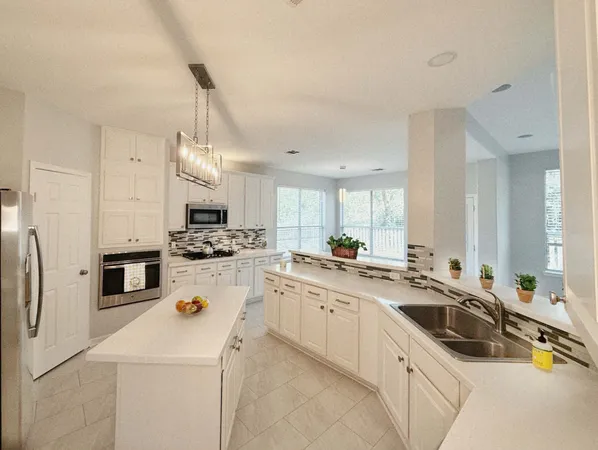 a kitchen that has a sink a stove and a refrigerator