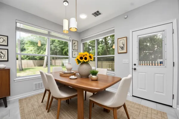 a dining room with furniture a chandelier and wooden floor