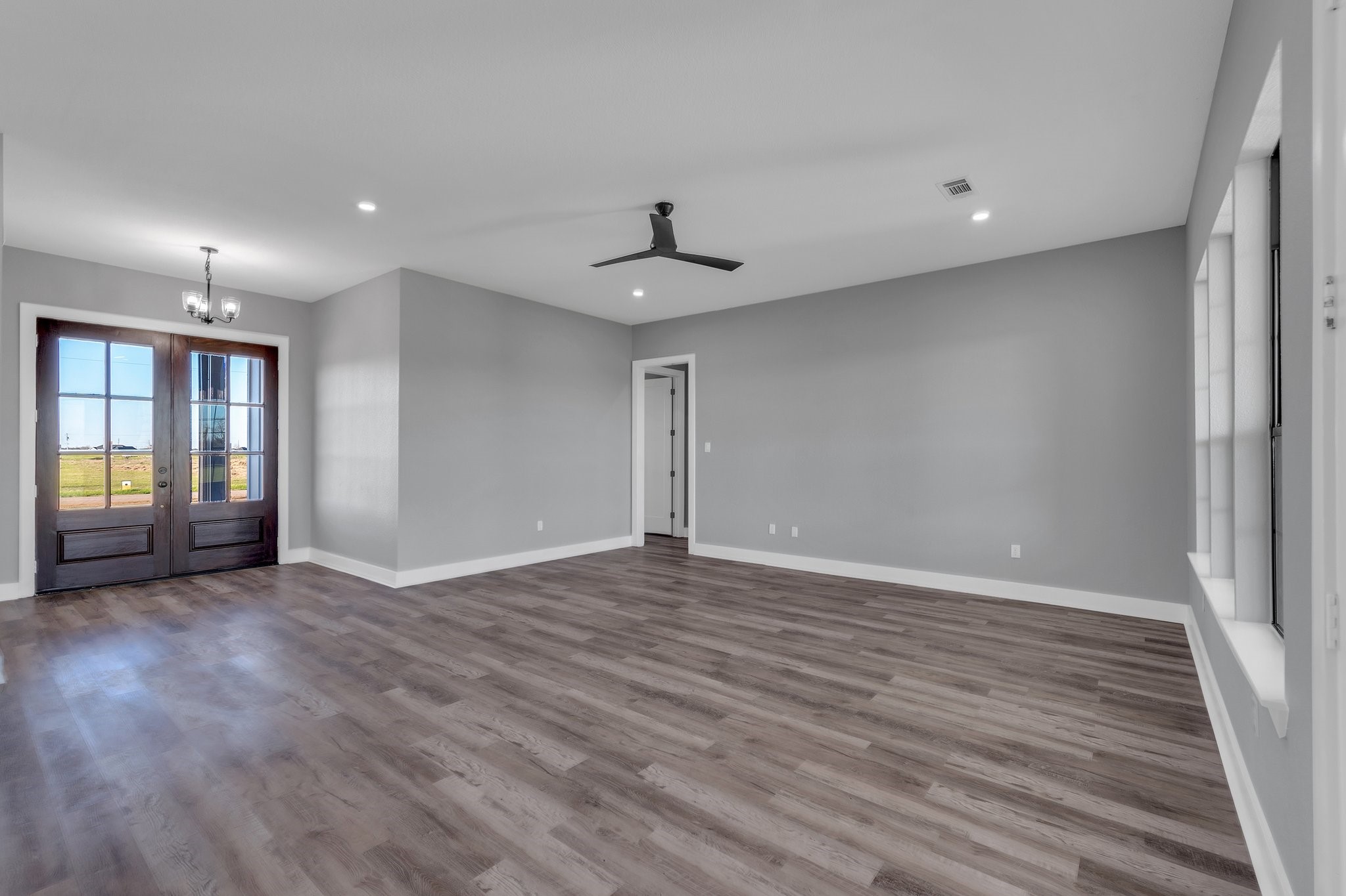 519 Chuckwagon Trail Angleton, TX 77515 - Photo 8 of 34 a view of an empty room with wooden floor and a window
