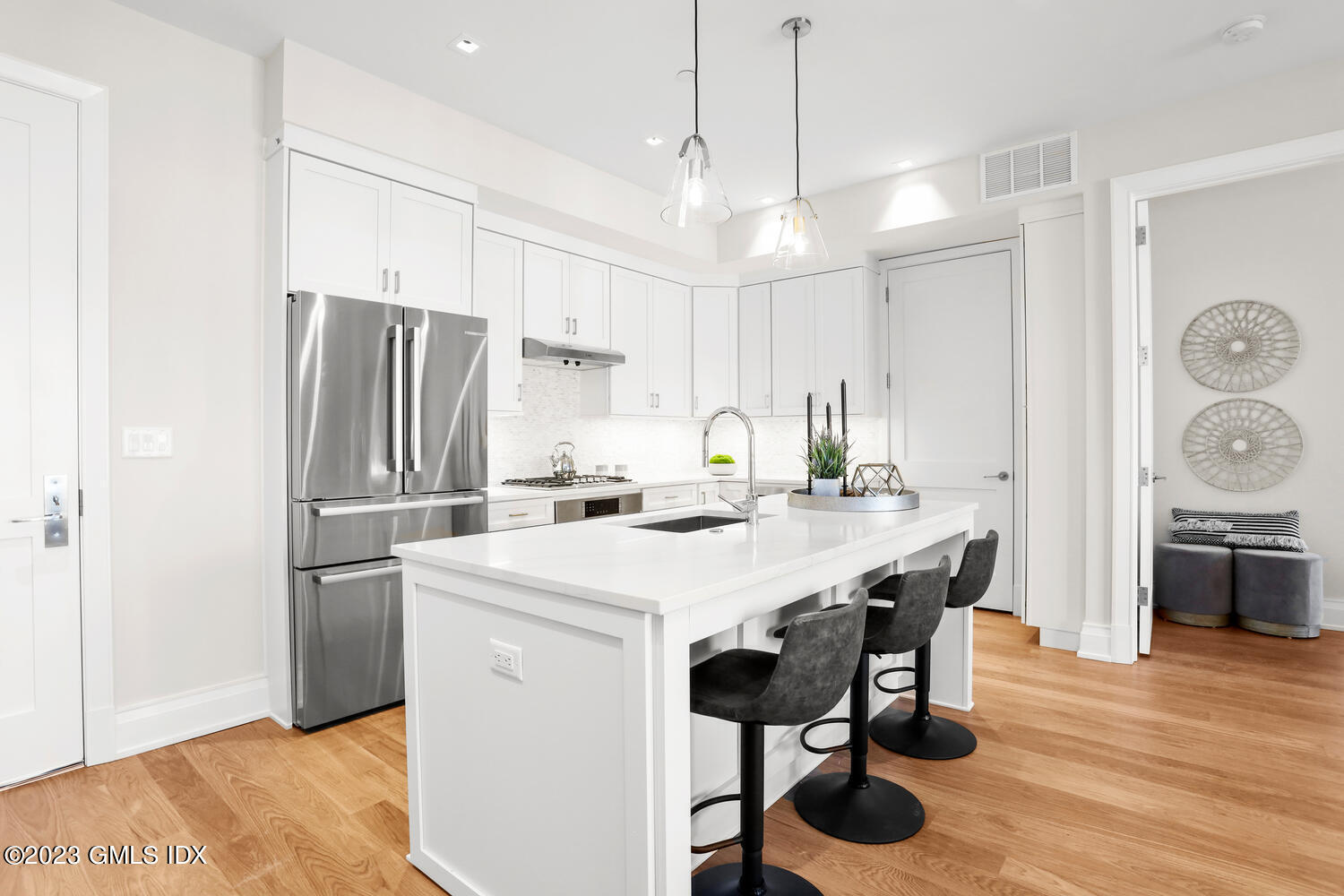 88 South Water Street, Unit 106 Greenwich, CT 06830 - Photo 5 of 24 a kitchen with stainless steel appliances a table chairs and refrigerator