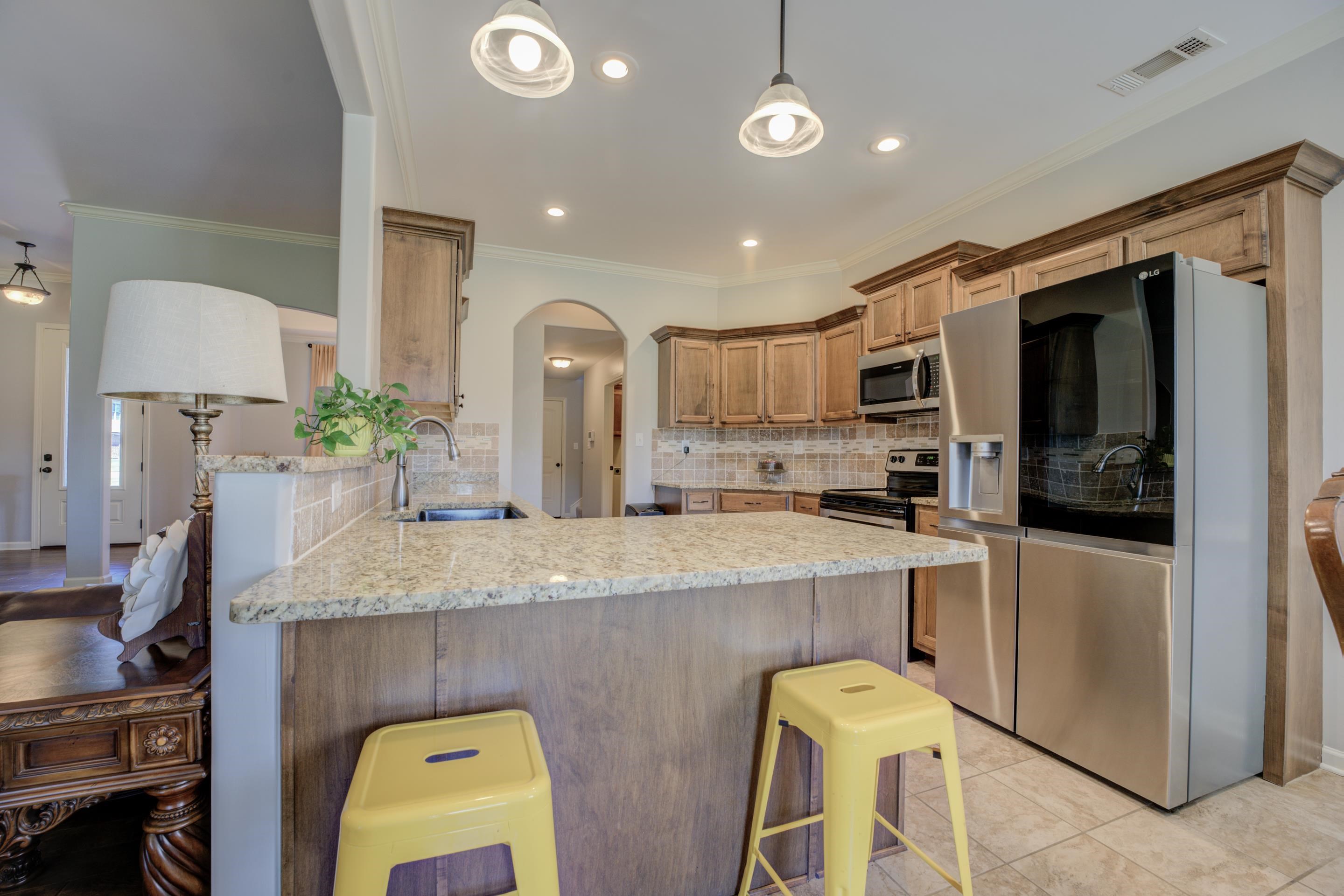 370 Pearl Road Somerville, TN 38068 - Photo 13 of 39 Kitchen featuring decorative backsplash, stainless steel appliances, sink, kitchen peninsula, and a breakfast bar area