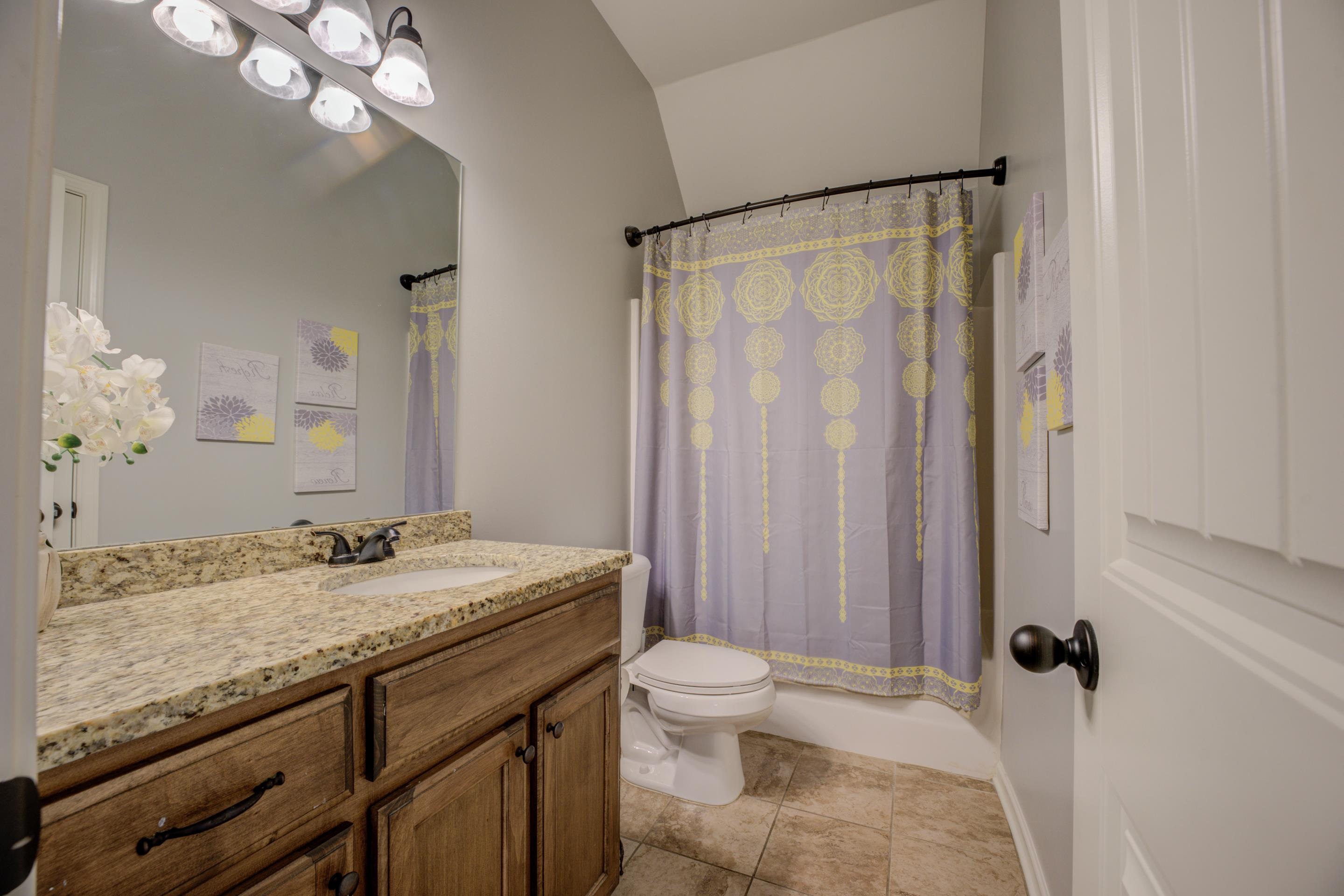 370 Pearl Road Somerville, TN 38068 - Photo 25 of 39 Shared Full bathroom downstairs featuring shower/tub combo, tile patterned floors, vanity.