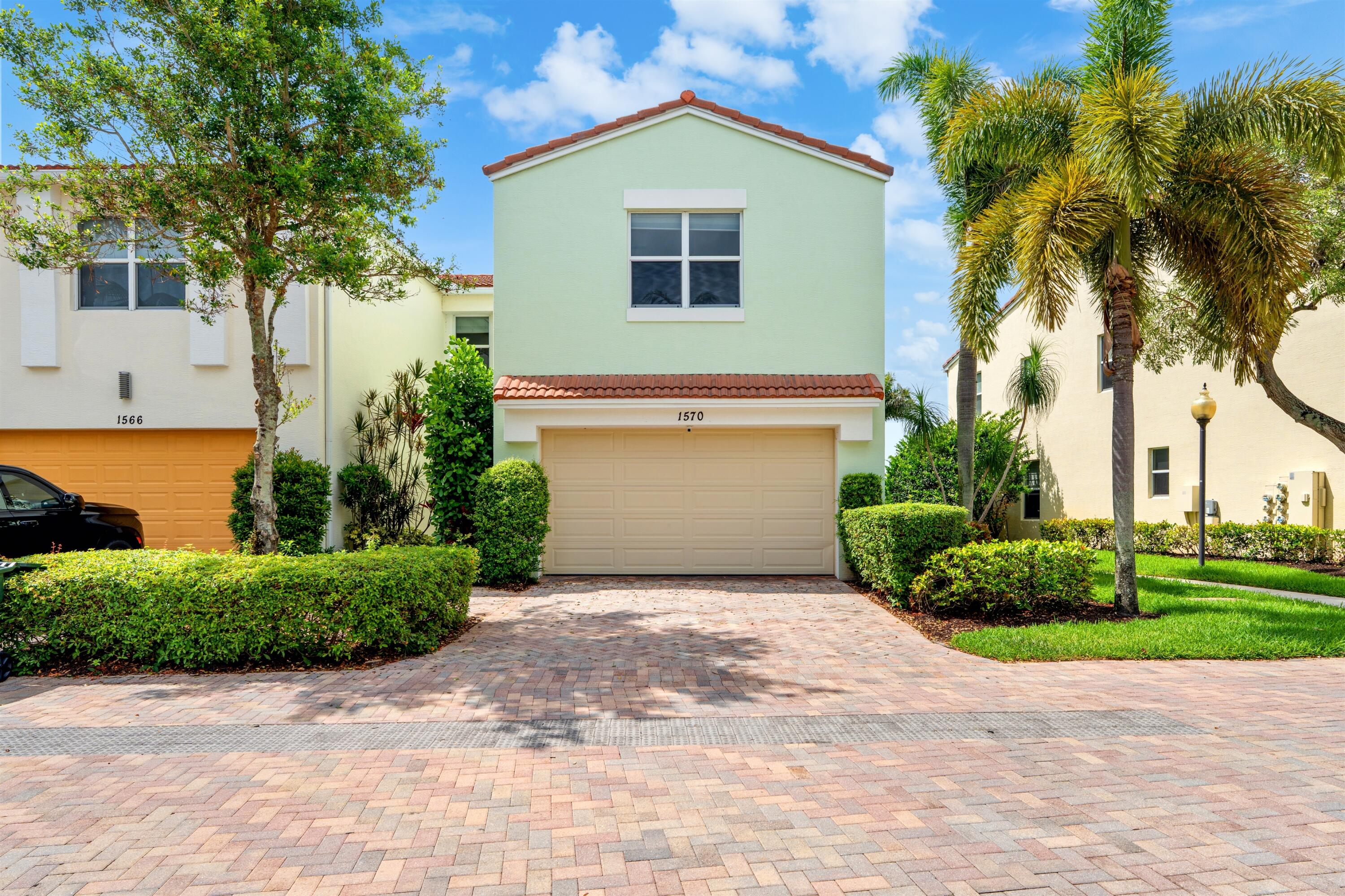 1570 Northwest 48th Place Boca Raton, FL 33431 - Photo 2 of 30 a front view of a house with a yard and a garage