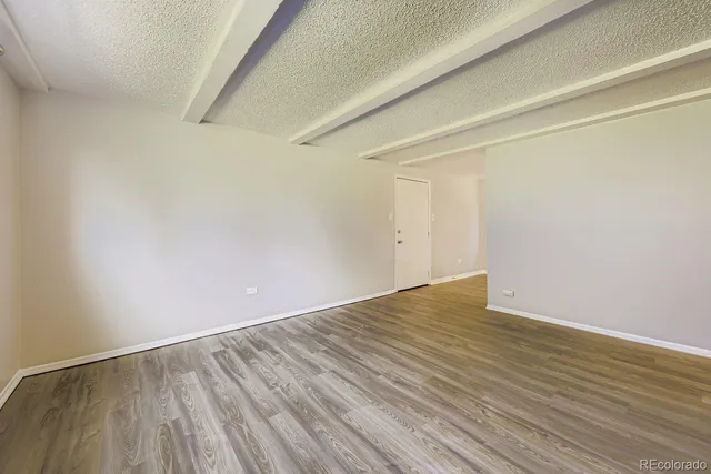 a view of an empty room with wooden floor
