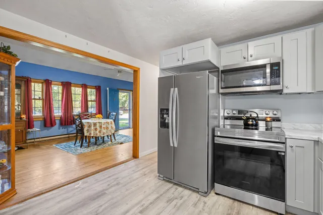 a kitchen with granite countertop a stove top oven and refrigerator