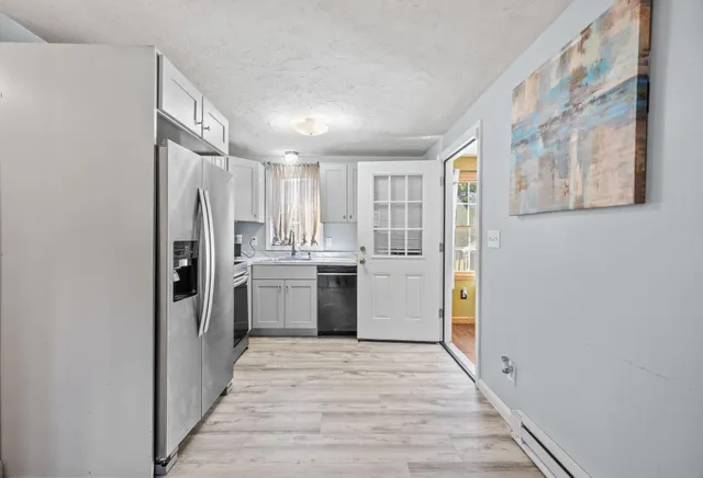a kitchen with a refrigerator sink and cabinets