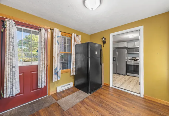 a view of a hallway with wooden floor and a bathroom