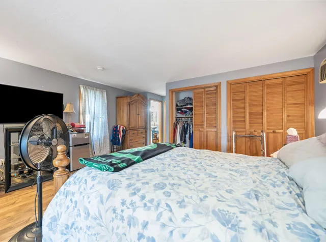 a bedroom with a bed mirror and a large window