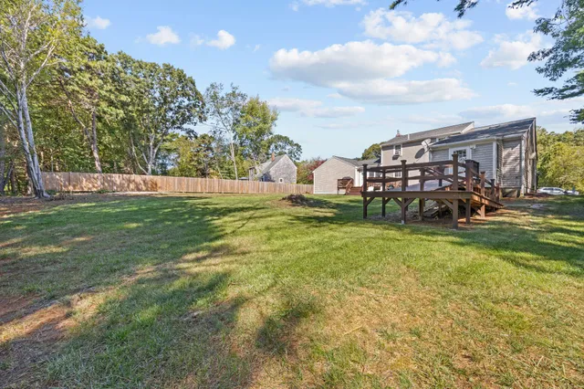a view of a house with a big yard and large trees