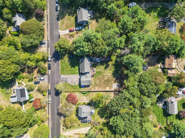 an aerial view of residential house with outdoor space and trees all around