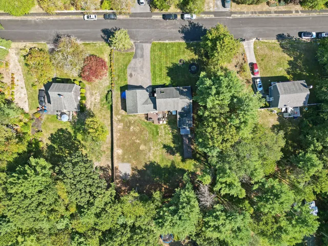 an aerial view of residential houses with outdoor space and trees