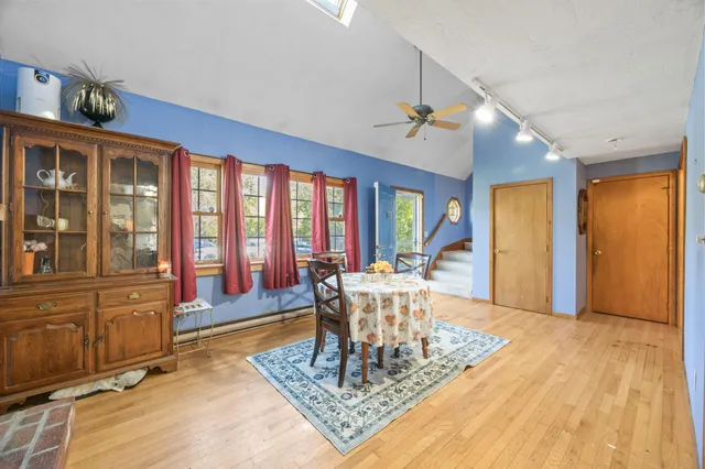 a living room with furniture large window and wooden floor